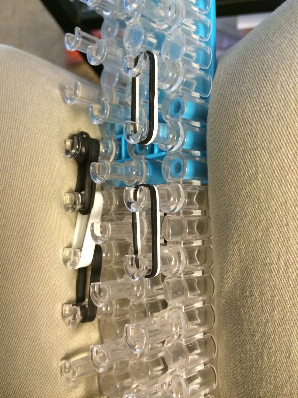 Place two separate sets of 1 white and black band. These are going to be our ears.