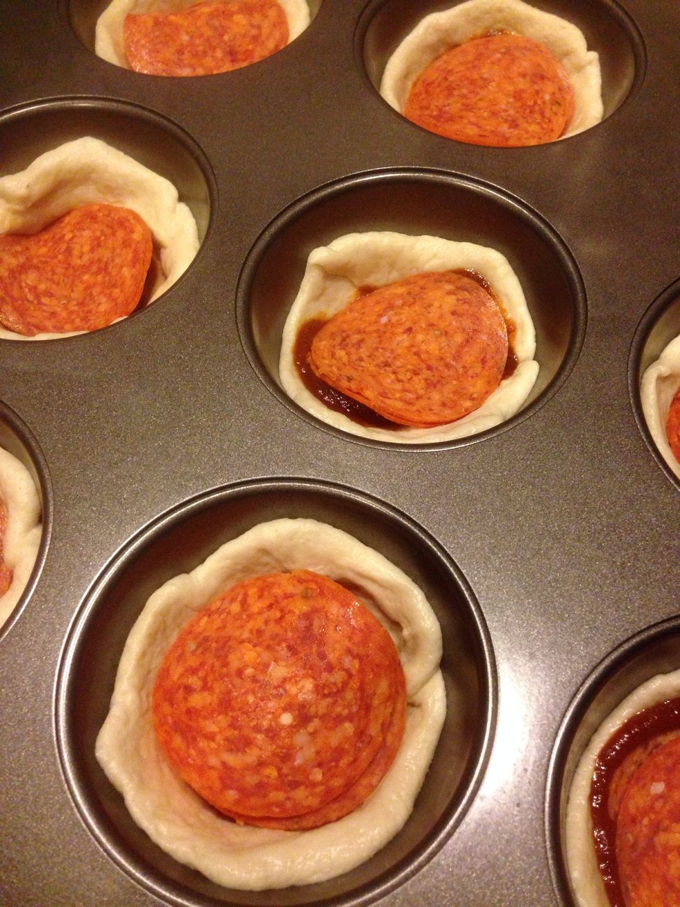 Place two slices of pepperoni over the sauce.