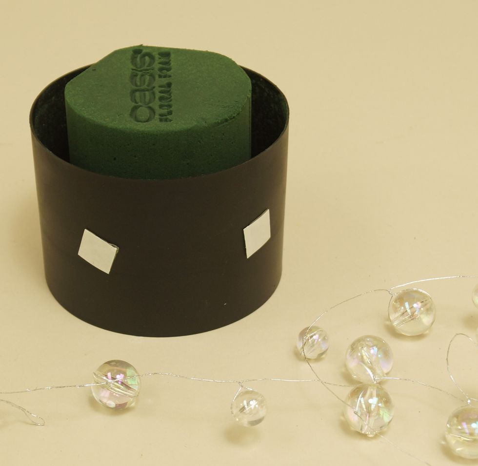 Place Uglu Dashes around container to hold Mega Beaded Wire in place. Be sure to peel off paper on both sides of dashes to adhere.