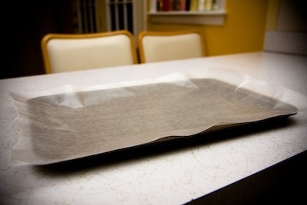 Place wax paper on top of a cookie sheet or baking pan and grease the surface with butter or cooking spray