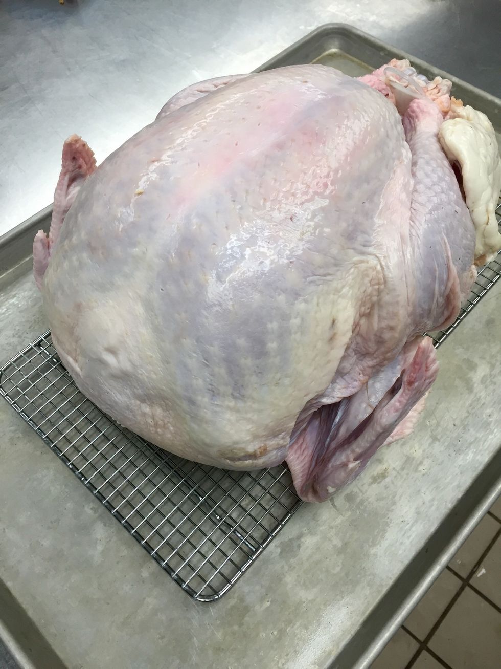 Place whole, de-thawed turkey on a sheet tray with an icing rack.