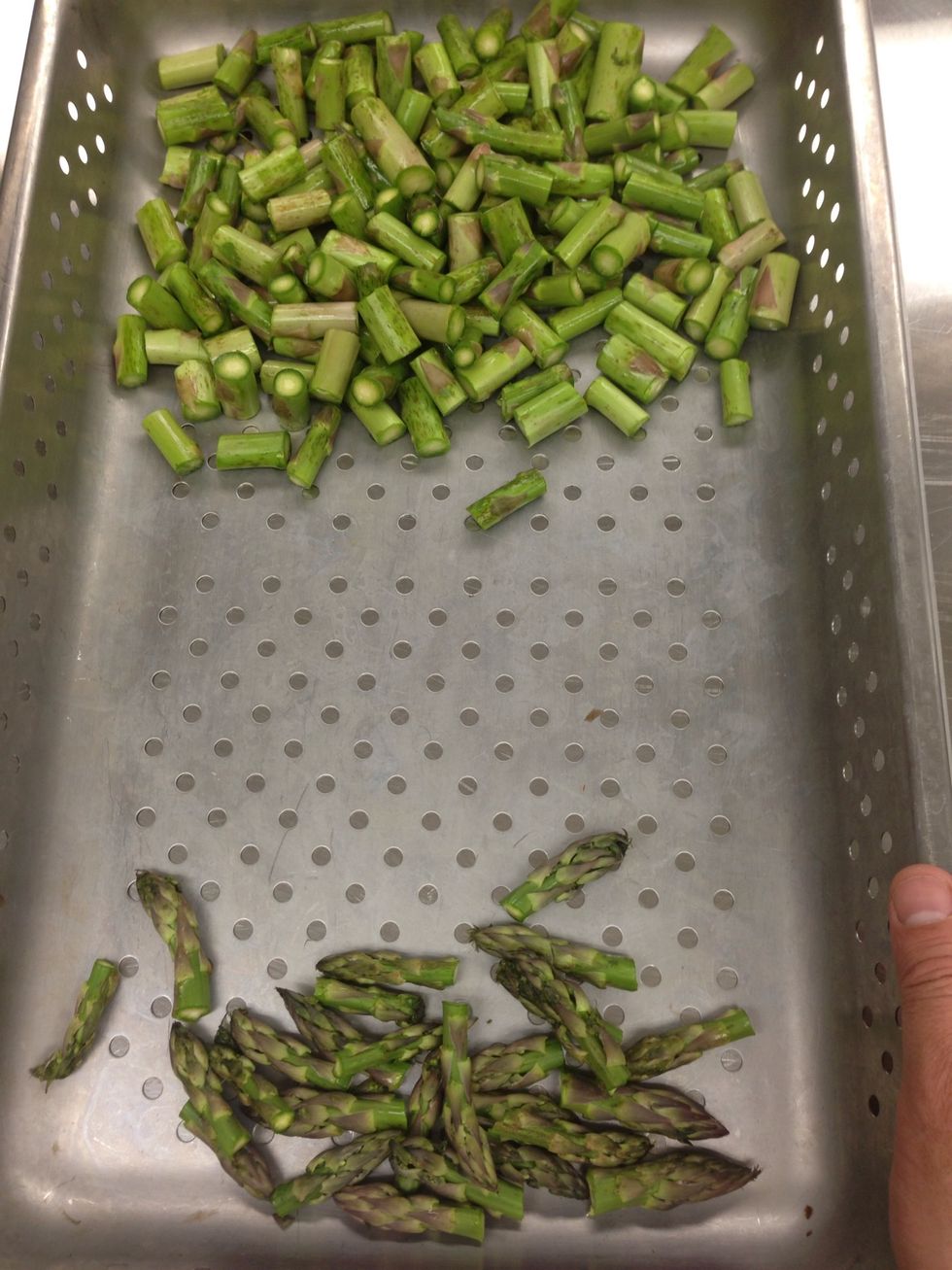 Place your asparagus into a perforated pan. Keep the tips separated from the stems.