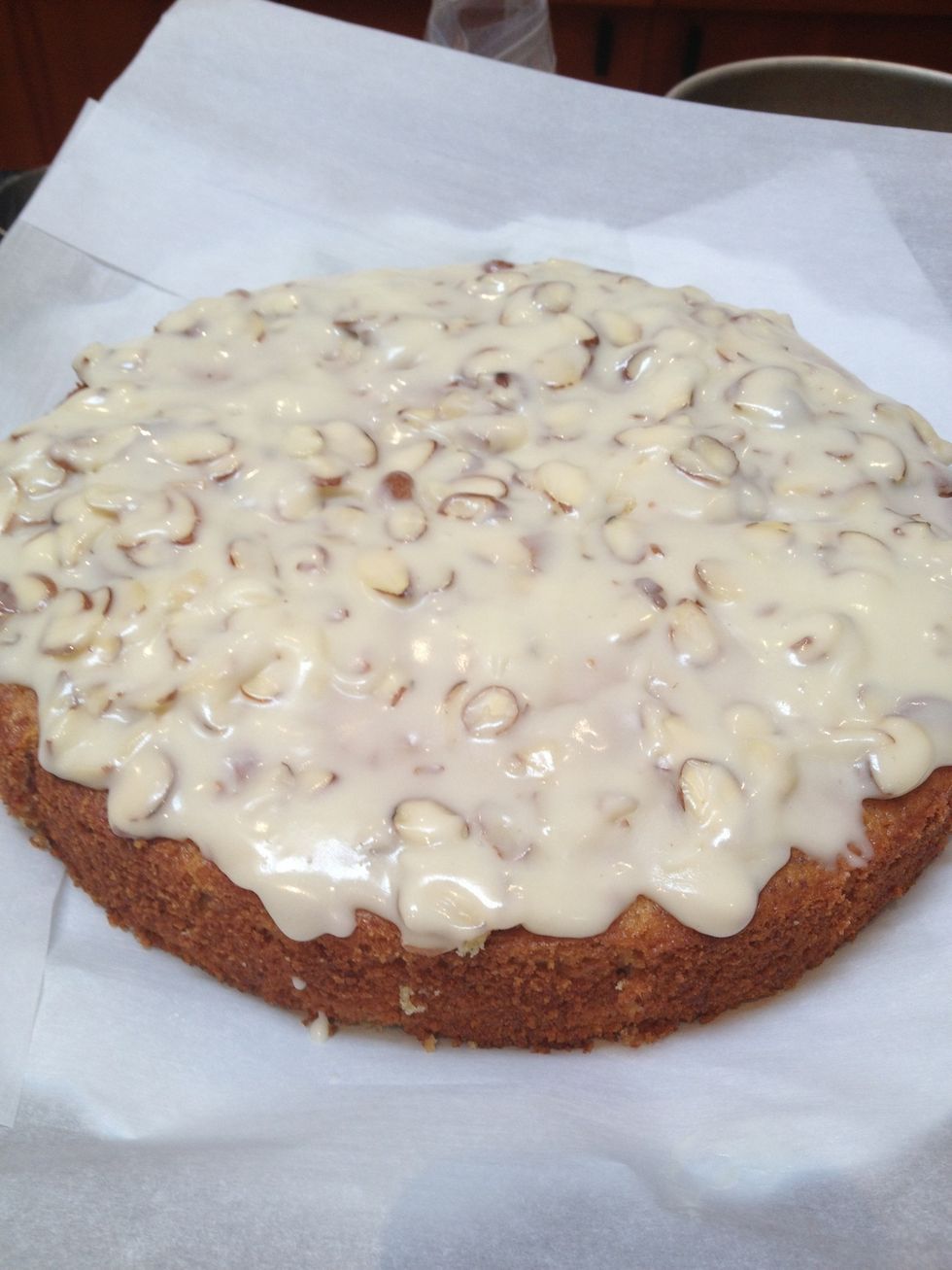 Place your cake on a plate, and line the bottom edges with strip of parchment paper to prevent messy glaze drips. Pour the glaze on top of the cake, and spread around with a spatula.