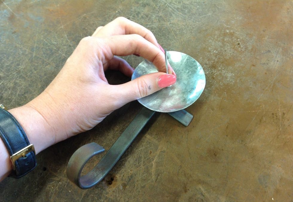 Place your dish inline with the feet and scroll. Place your pop rivet pin place it through the hole.