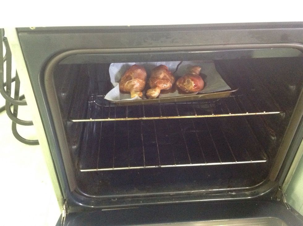 Place your drumsticks on the baking tray and pour 3/4 of the remaining marinate onto the chicken. Then place the drumsticks into the oven.