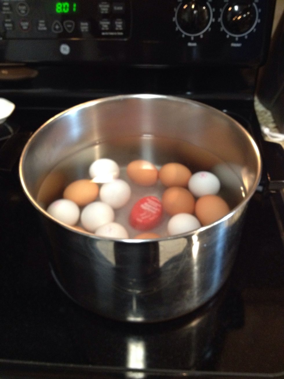 Place your eggs in pan large enough to cover with at least two inches of COLD water. Add 1 Tbsp Salt. Turn on high heat UNTIL it starts to boil.    I have an egg timer in the bottom (not necessary).