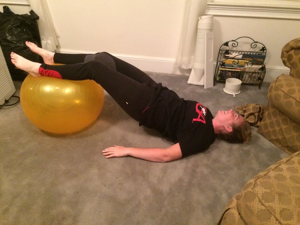 Place your feet on the ball with your shoulders on the ground keeping your stomach and lifted away from the ground.