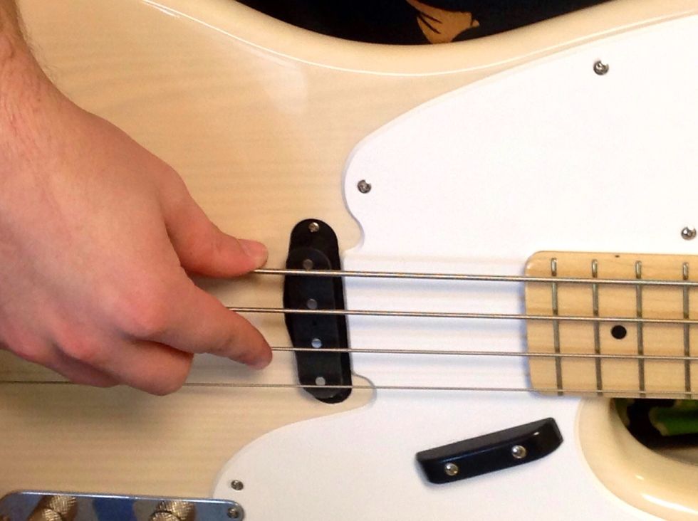 Place your finger on the D string, or the second to the bottom string.