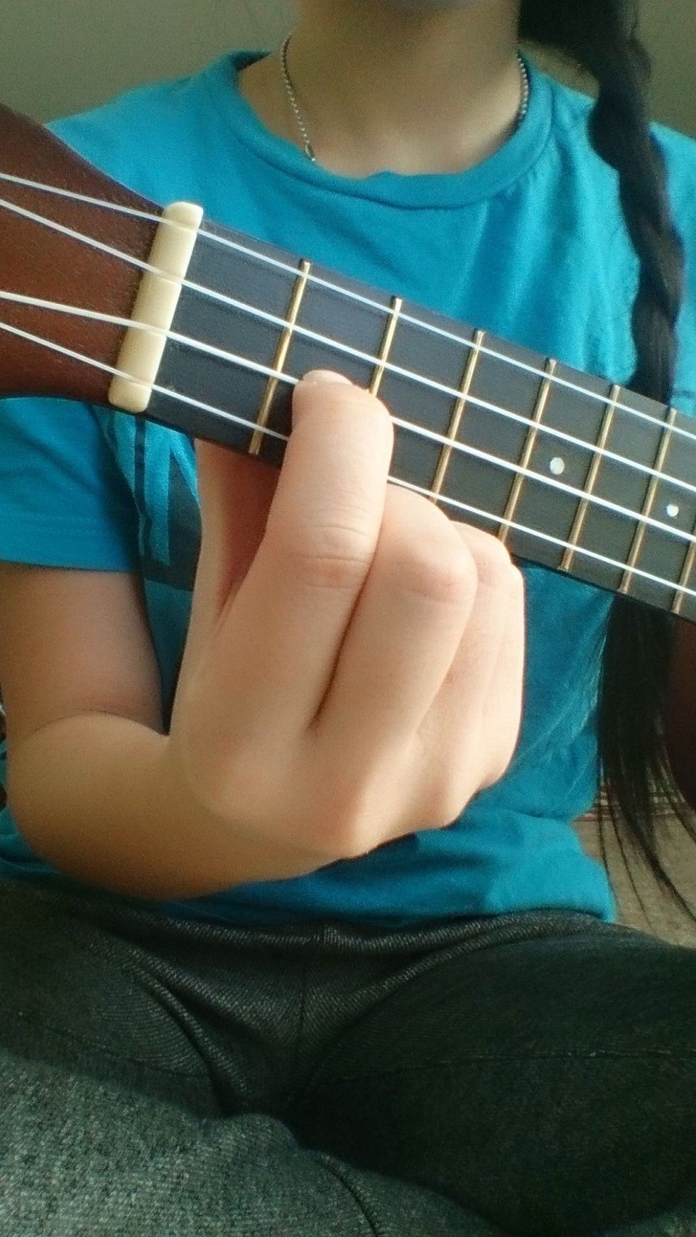 Place your index finger on the second fret , " C " string