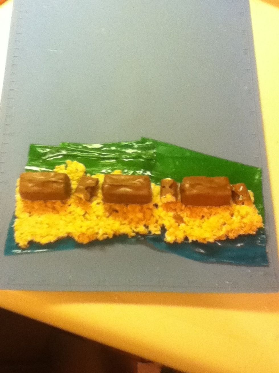 Place your little candies in a nice line towards the middle of the crispie part. I used Snickers and a normal Hersey bar cut up, but you can use whatever you prefer :)