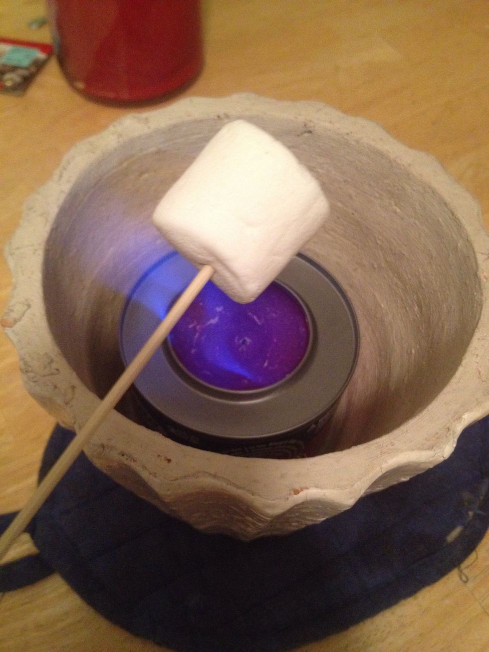 Place your marshmallow on a kebab stick and warm it over the flame. DO NOT DO THIS UNLESS A RESPONSIBLE ADULT IS THERE.