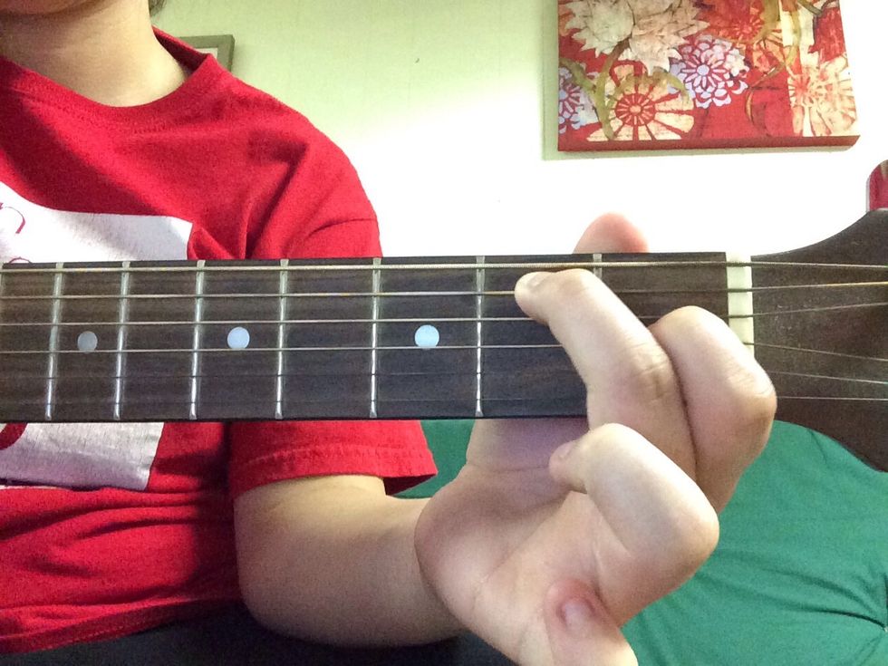 Place your middle finger on the A string on the second fret.