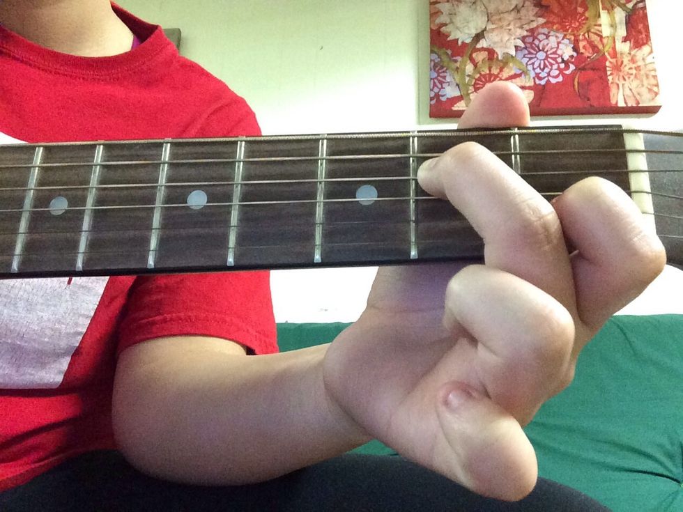 Place your middle finger on the D string on the second fret.