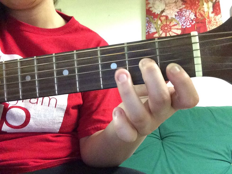 Place your middle finger on the G string on the second fret.