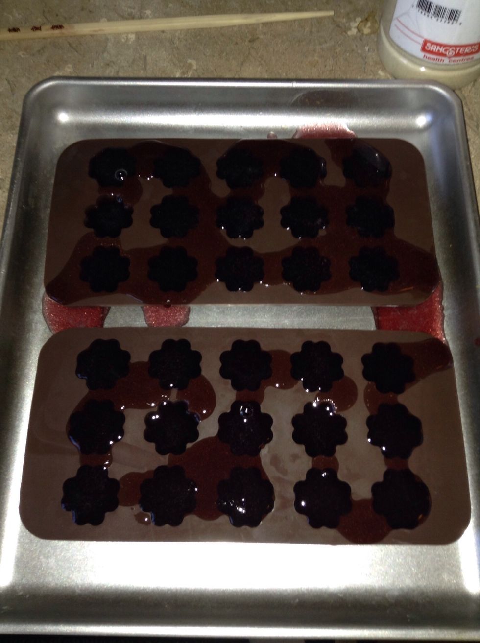 Place your moulds on a baking sheet for stability.  Carefully pour gelatine mixture into your moulds.  My moulds hold aprox. \u00bc cup each so I use 4 that have 15 moulds each which yields 60 jelly's.
