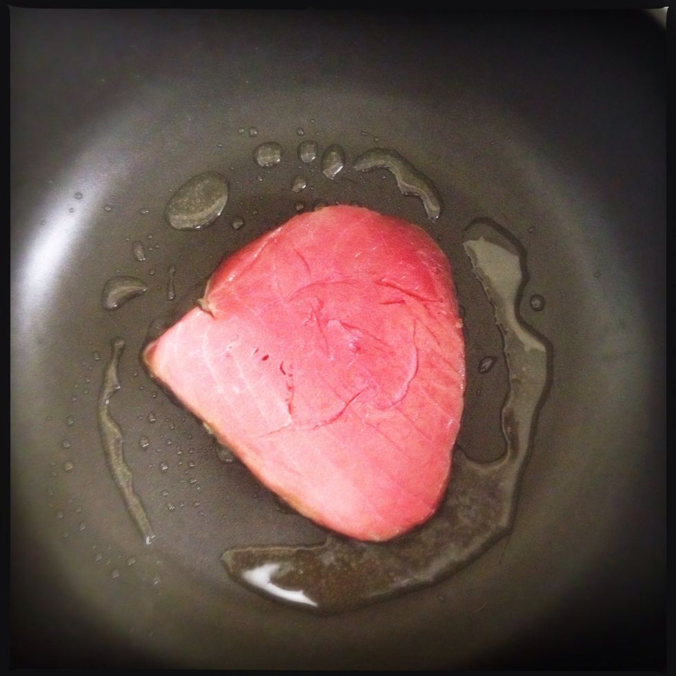 Place your pan over a medium-hot heat. Once hot, add about half a tablespoon of olive oil, let the oil heat up and add your tuna.