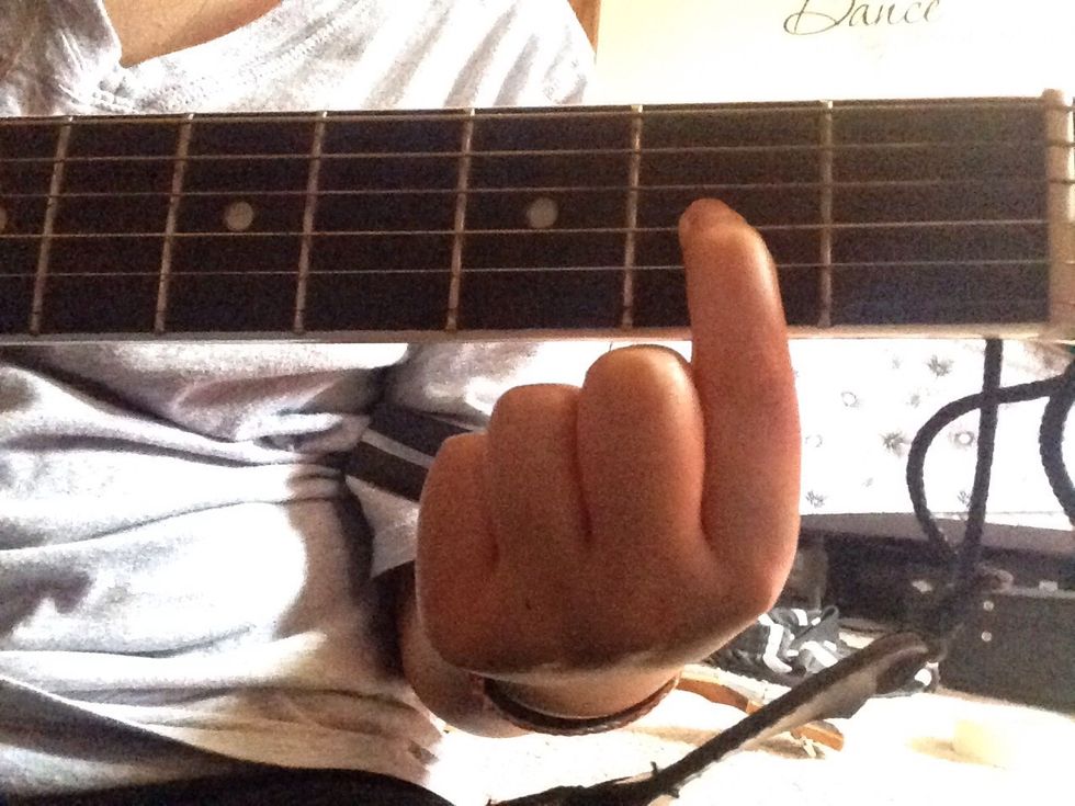 Place your pointer finger on the G string in the second fret.
