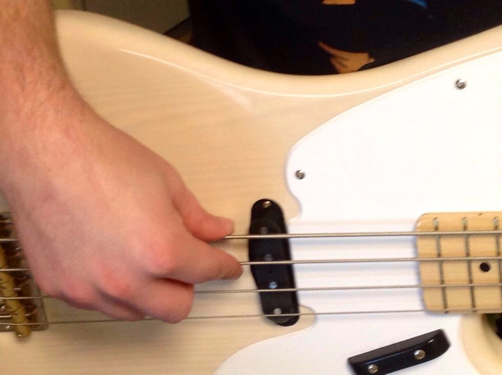 Place your preferred finger on the A string, the second to top string.