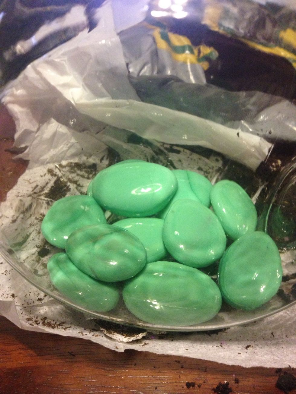 Place your rocks at the bottom of the jar. These are glass stones from the dollar store. You can also use rocks from outside. Stack a couple layers to provide drainage and a nice look.