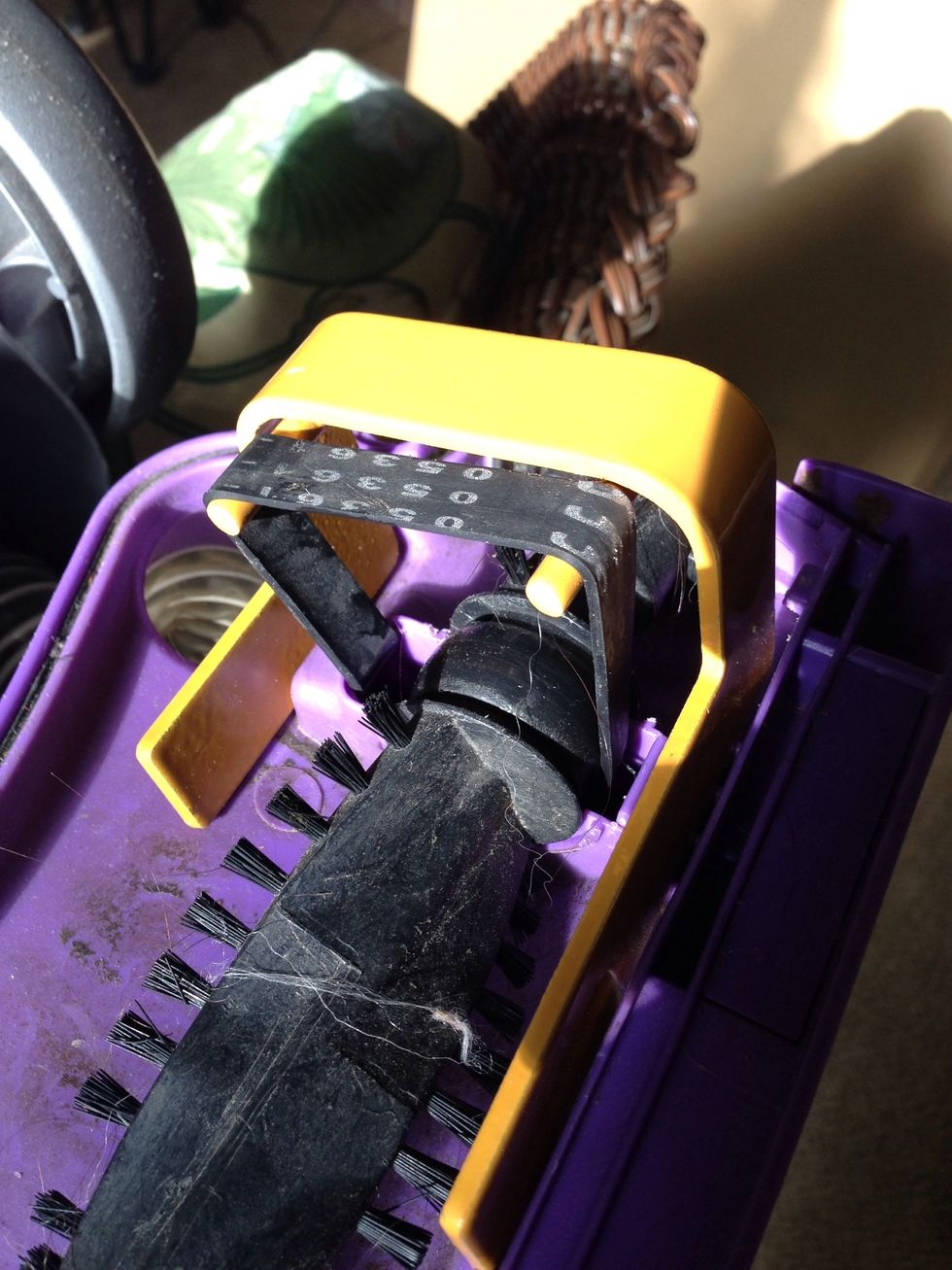 Place your roller under the stretched belt. The roller has a left side and right side. Place the end with the belt guide under the belt. Remember to align the roller so the flat ends face away.