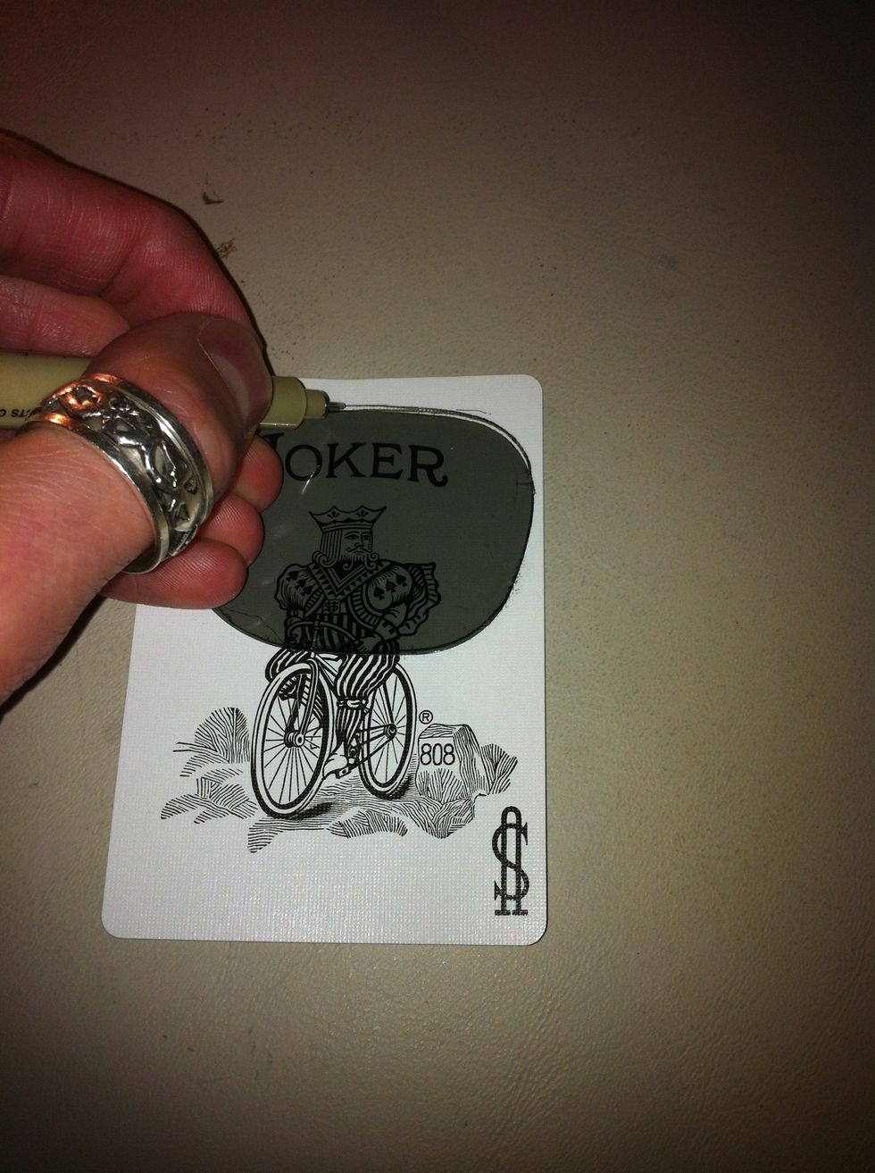 Placed the lens over the card where you want the picture to be seen. Make sure the word joker is inside. Then trace the lens outline.