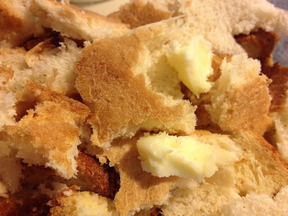 Places chunks of butter randomly over the bread pieces..