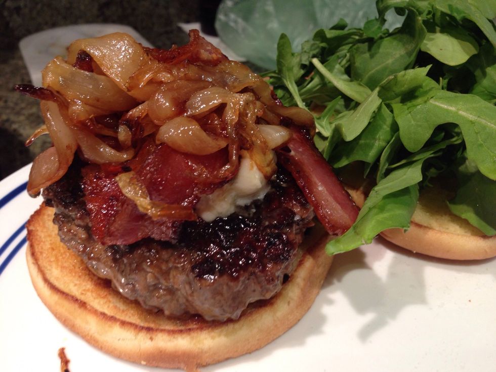 Plate, top burger with onions, place a helping of arugula on the top of the bun.