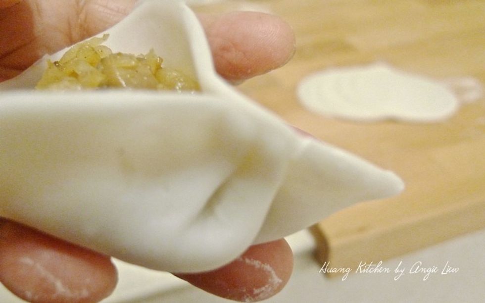 Pleat one side of the edge of the wrapper and secured to the other side into a half moon shape.