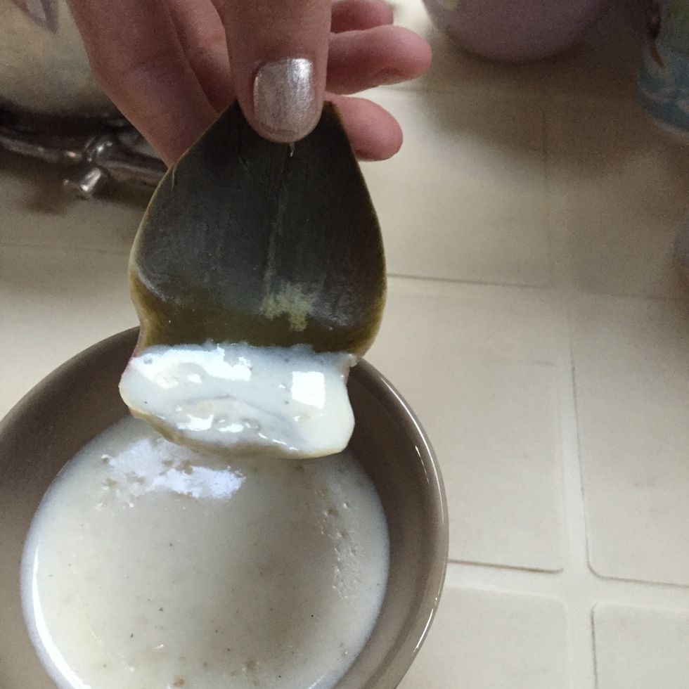 Plongez le c\u00f4t\u00e9 oppos\u00e9 \u00e0 la pointe (celui par lequel \u00e9tait rattach\u00e9 la feuille \u00e0 l'artichaut) dans la sauce de votre choix. Tirez entre vos dents de mani\u00e8re \u00e0 attraper la partie molle et la sauce.