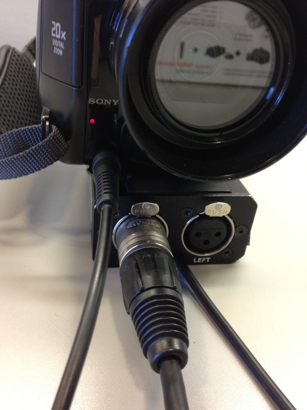 Plug the BeachTek into the front of the camera. Use an XLR cable to plug a microphone into the BeachTek.