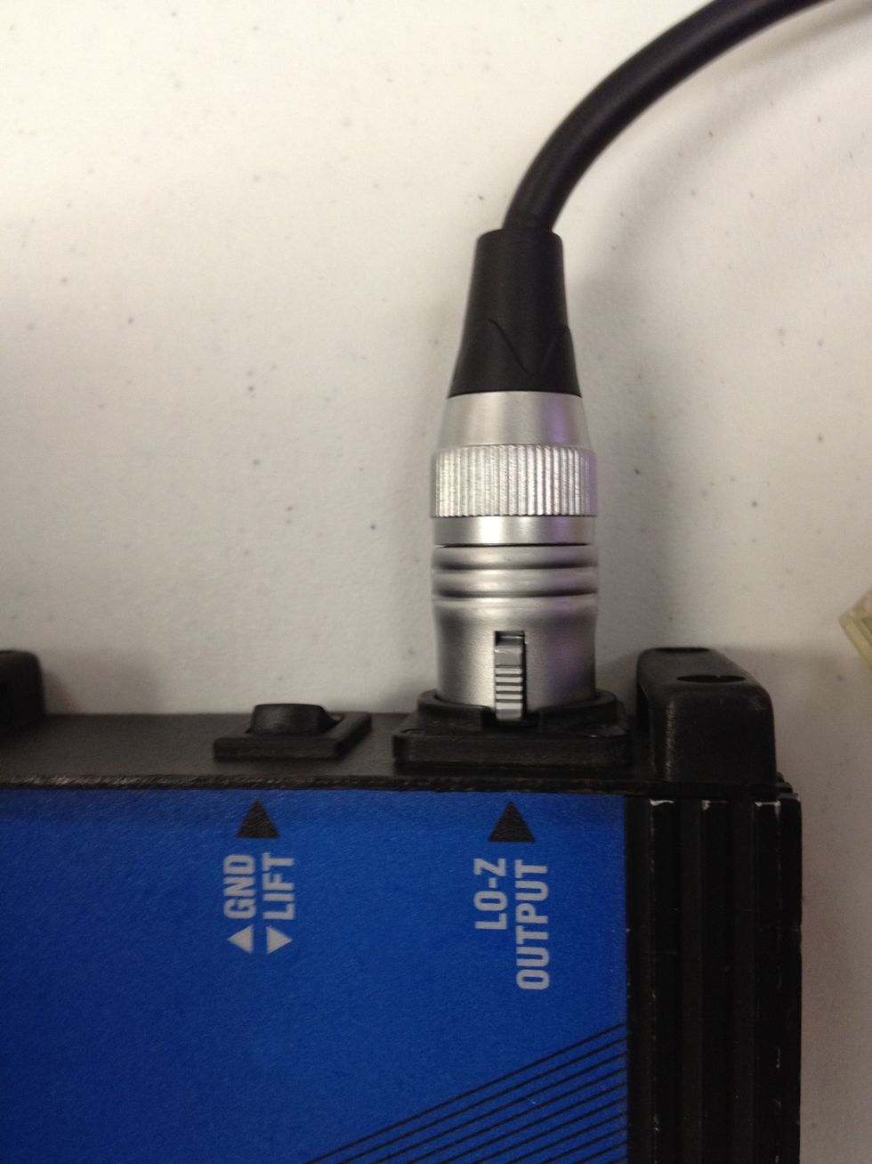 Plug the microphone cable into the OUTPUT of the DI box. Pro tip for later - if you get a hum when playing sound, flicking the switch here (ground lift) will probably fix it!