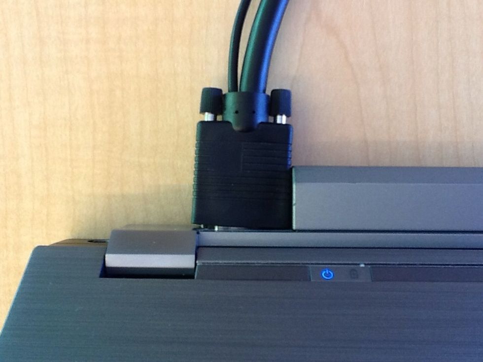 Plug the VGA cable that is provided into the port on the laptop.