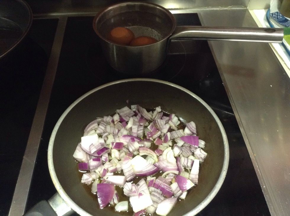 Pochar cebolla roja, y poner unos huevos a hervir
