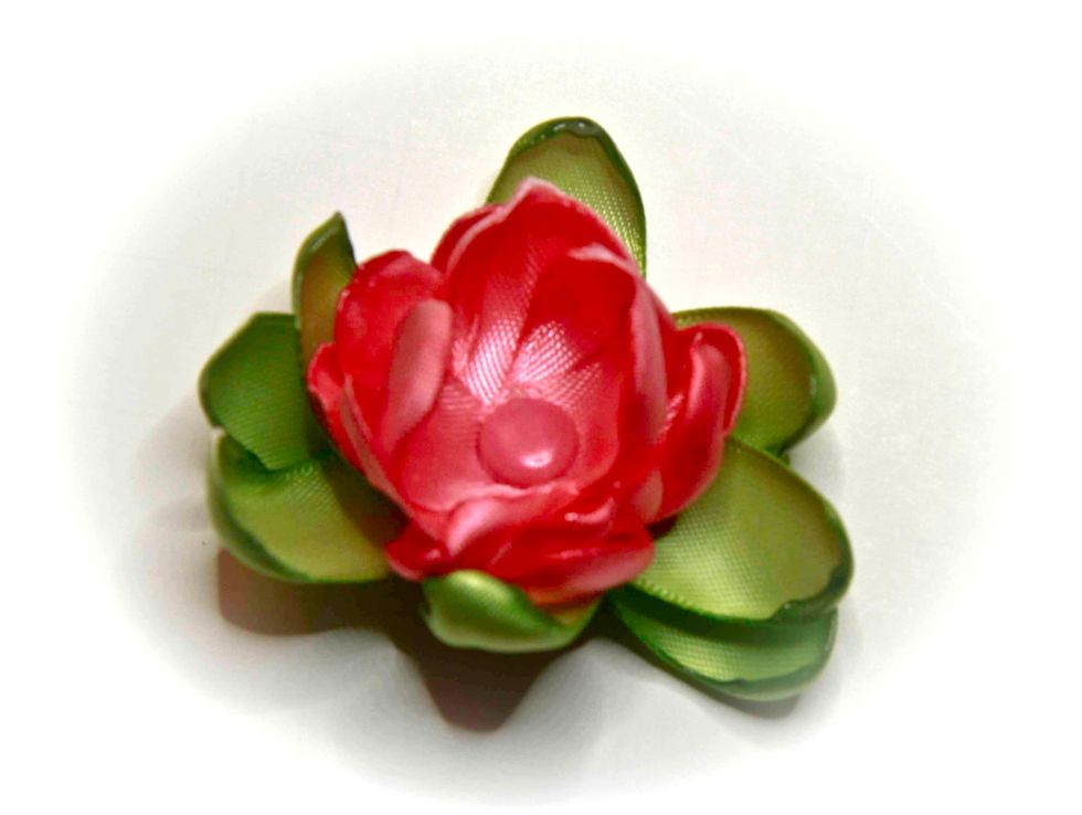 Poke a hole in the center of each piece of ribbon and insert a brad. Move the petals and leaves around to form your flower.