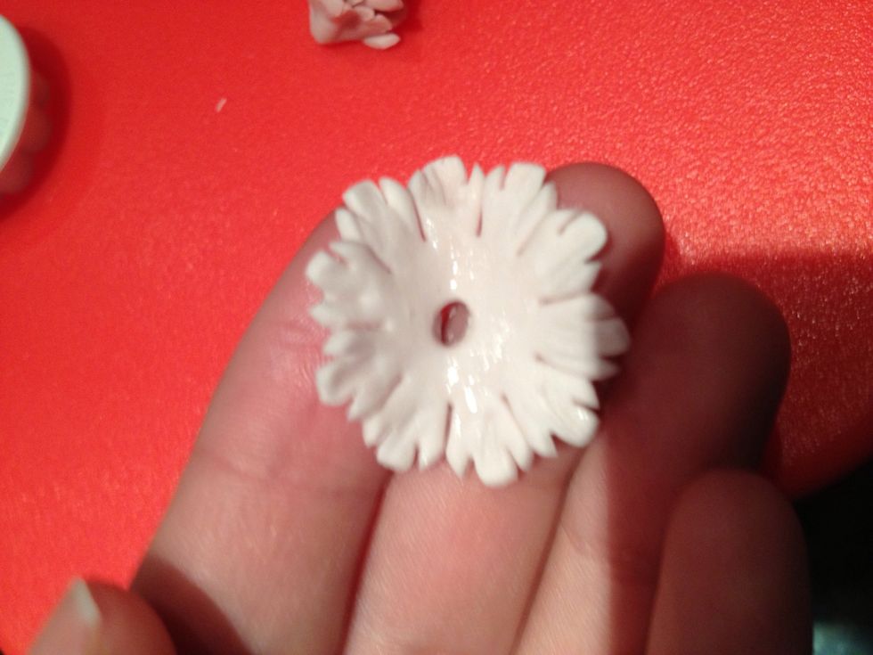 Poke a hole in the last flower and glue it around the edge.