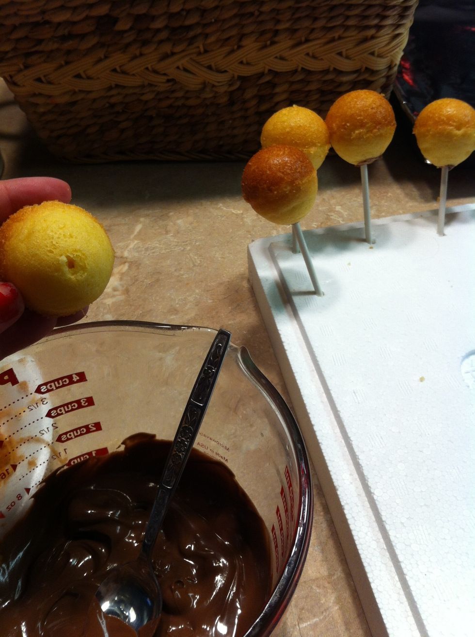 Poke a hole in the pop, fill with almond bark, and insert the stick. I put the stick in a block of styrofoam to let the chocolate harden. This will keep the pop from falling off while coating.