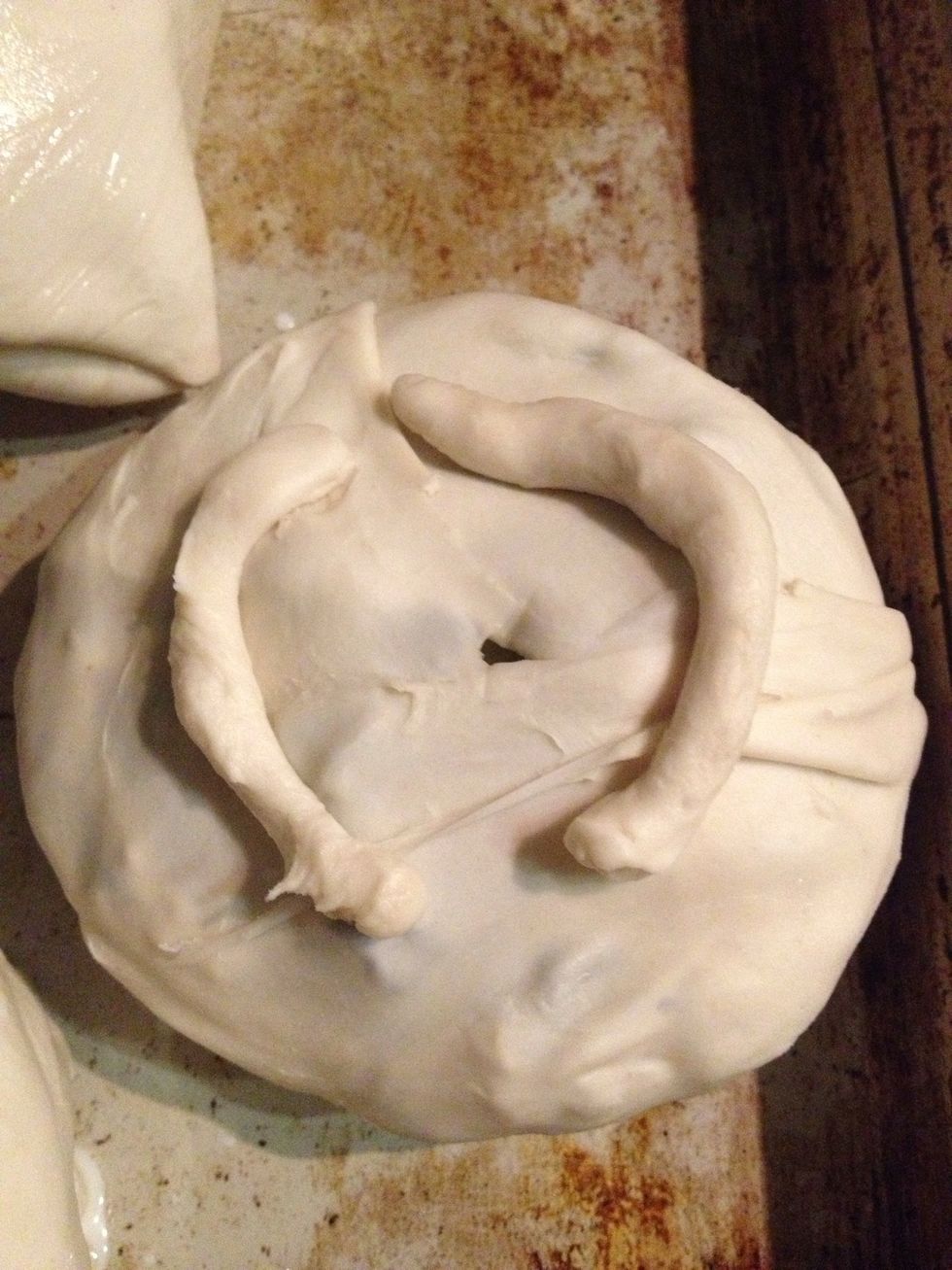 Poke a hole in the top and place in a greased pan in the oven at 220\u00b0c till golden brown 15-20 min