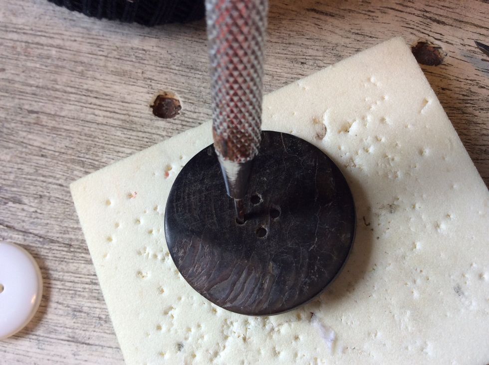 Poke holes through button using a paper piercing tool (a pushpin will work if you don't have a paper piercer).