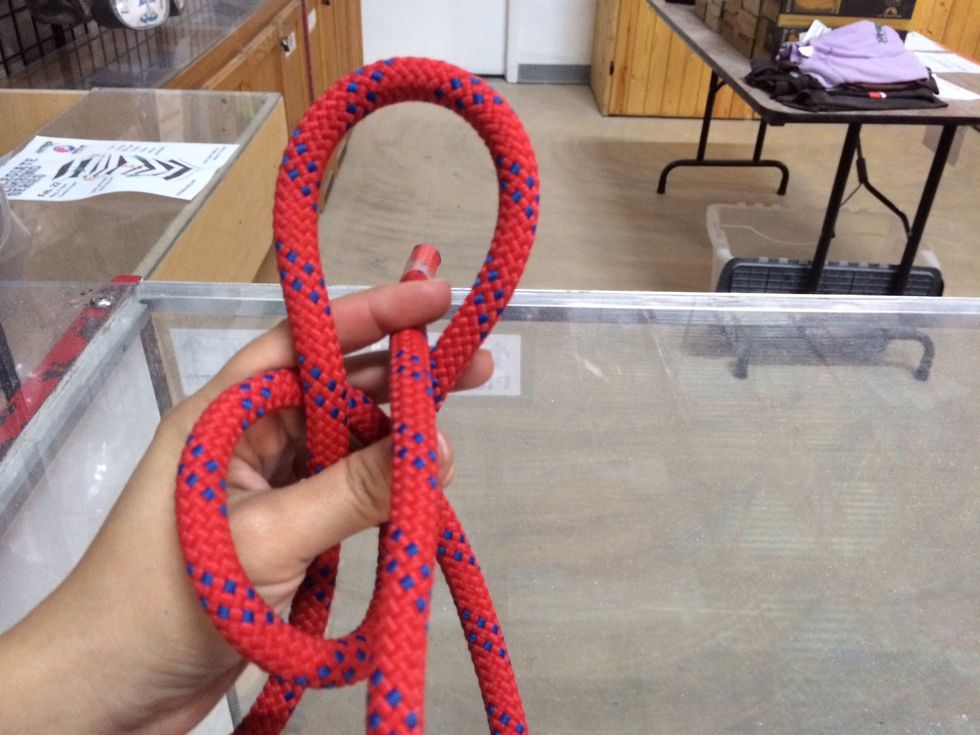 Poke the short side (tag end) of the rope through the hole and away from you. Think of this is poking the "bad guy's" eye out.