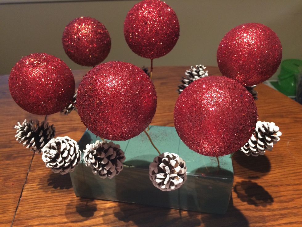 Poke the wire of the painted cones into the floral block and leave them to dry. Another option if you don't want to do the glittering and painting is to buy them already finished.