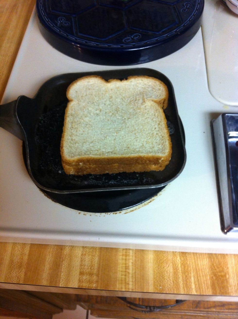 Pon el pan encima de mantequilla y anade queso y anade pan de Nuevo