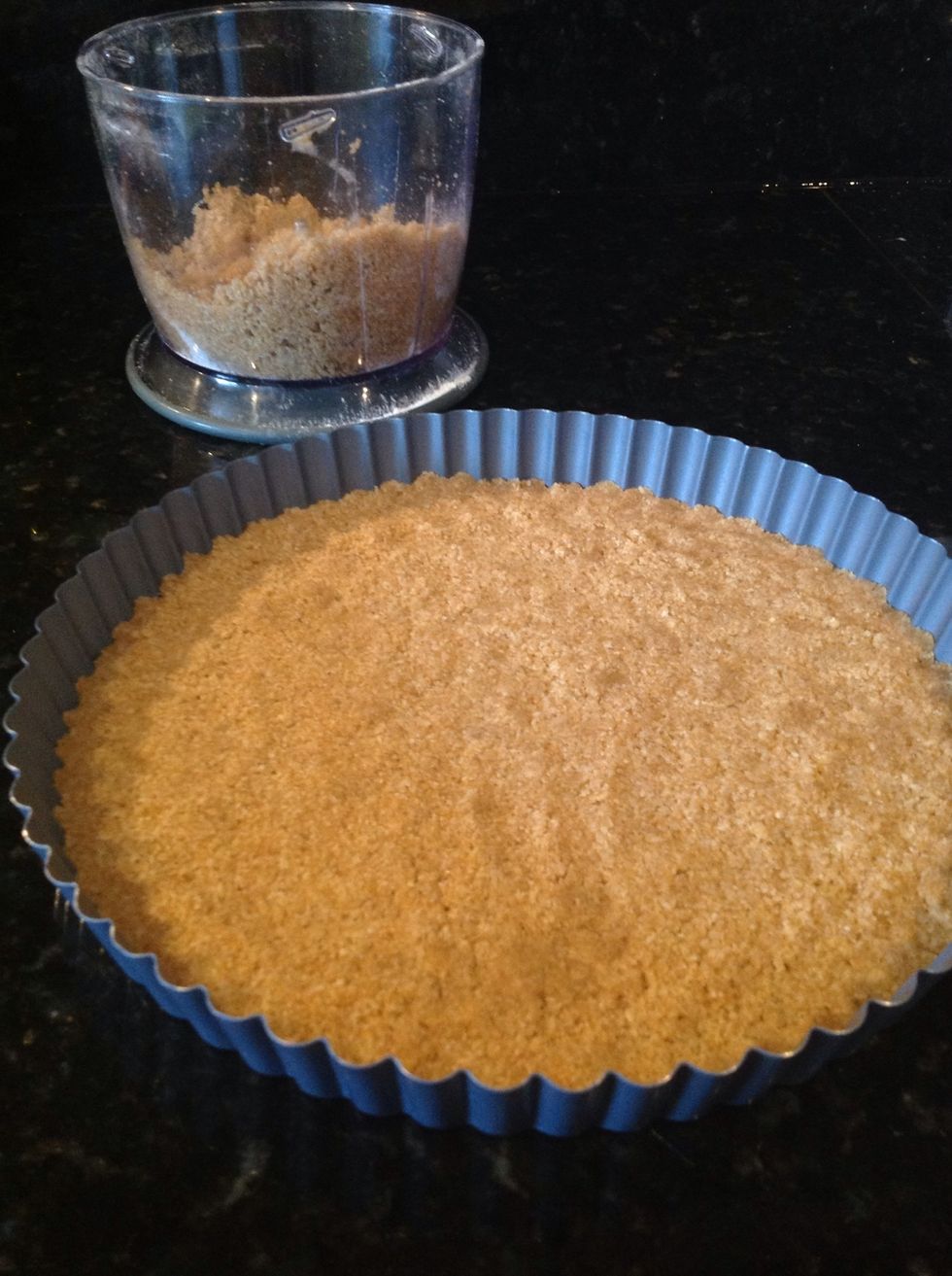 Pon la mitad de la mezcla en un molde redondo para horno y hazle presi\u00f3n para que compacte.