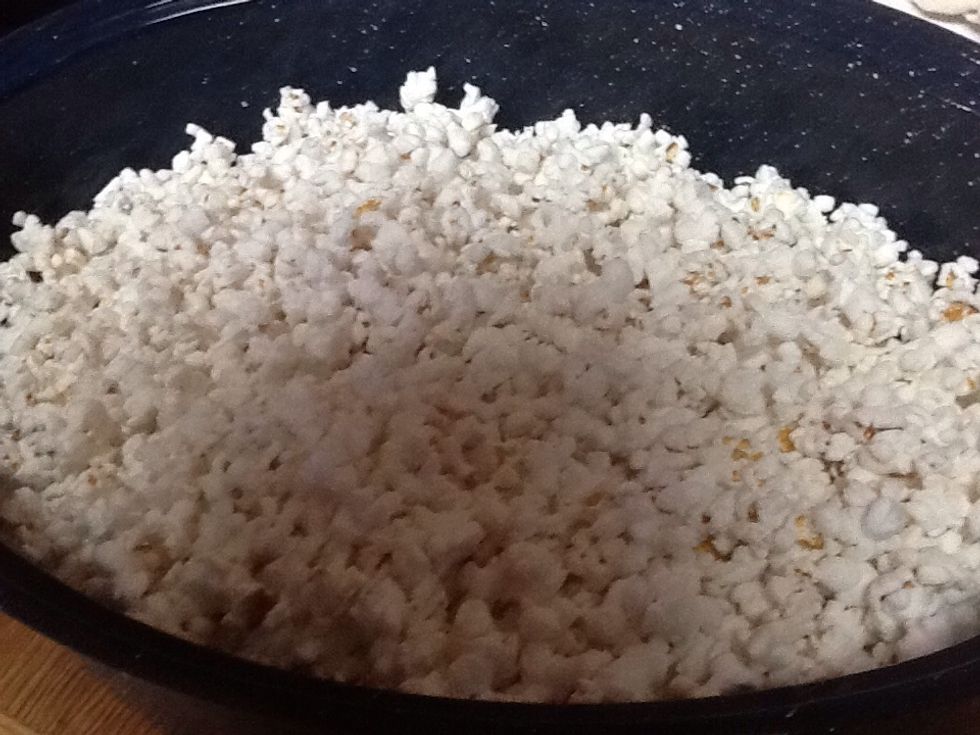 Pop popcorn 4 quarts. spray large shallow roasting pan with cooking spray. Add popcorn and place in preheated 250 degrees F oven while preparing caramel.