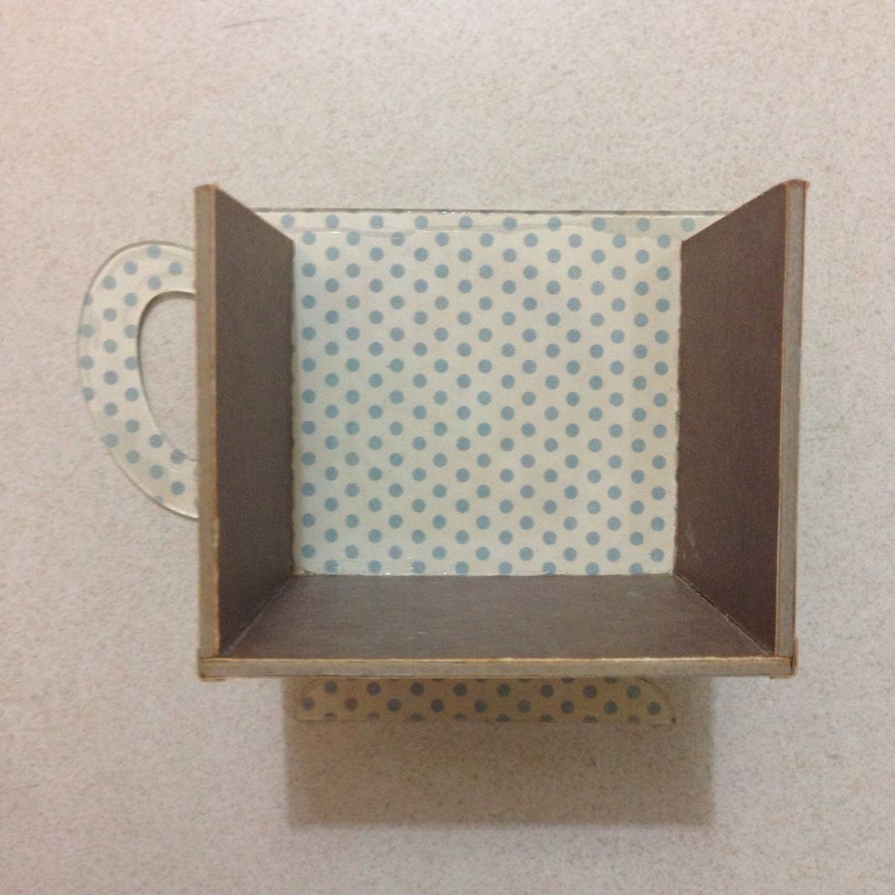 Position it well on the reverse side of the teacup (unglued plastic side) and glue it down...