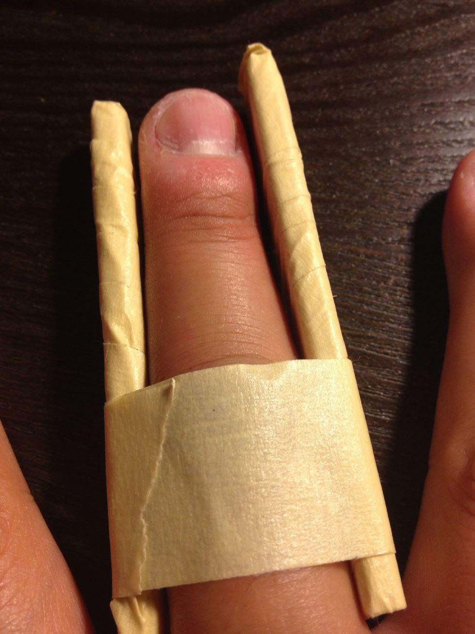 Position the 2 pieces on each side of the injured finger and wrap a piece of masking tape around it. Don't wrap it too tight, just enough to keep the finger straight.