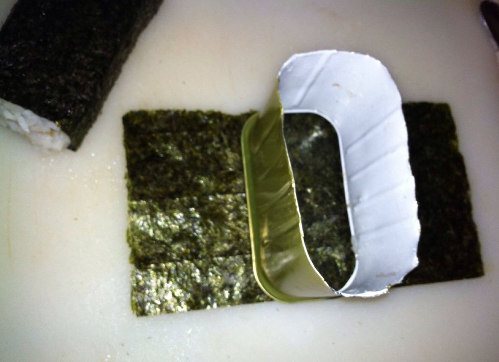Position the musubi-mold in the middle of the nori. (If you don't have a musubi-mold, you can do what I did and make a ghetto mold by cutting out the closed end of the Spam can... ahahaha)