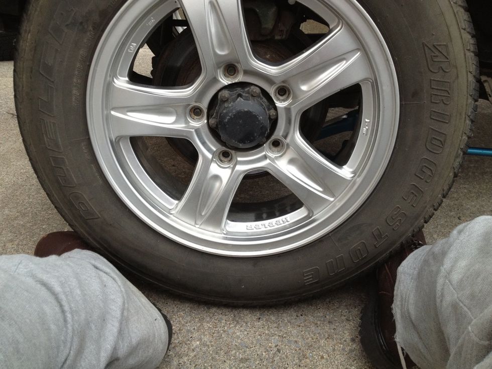 Position the new wheel on the studs. Sometimes it's useful to balance the wheel on your feet (but be very careful! And don't put your feet directly under the tire.).