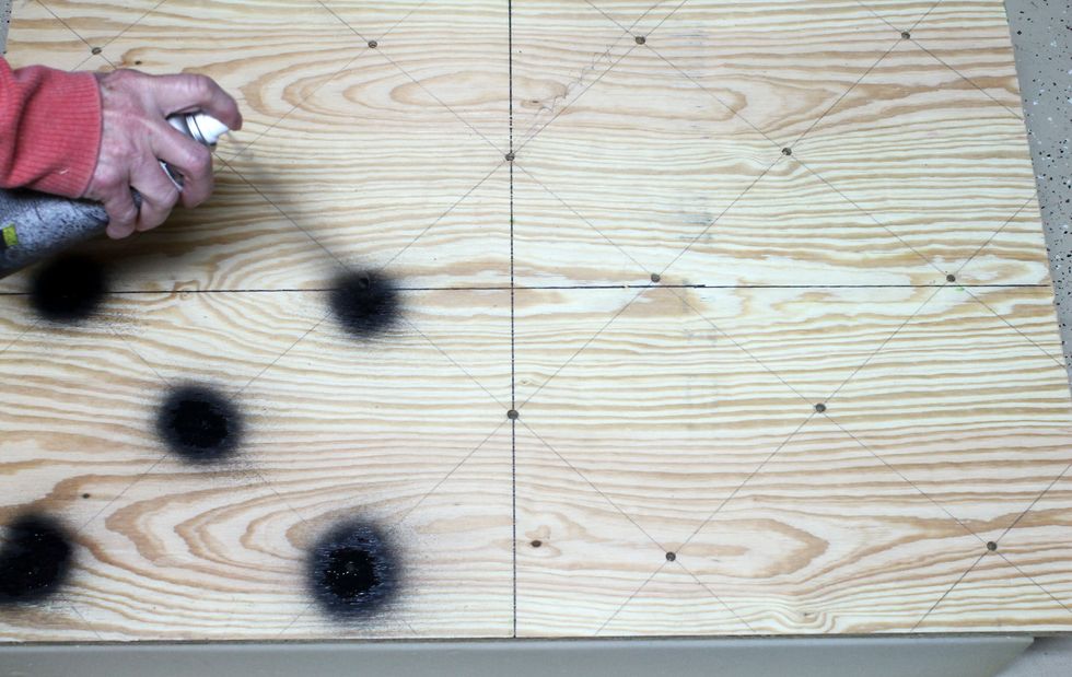 Position the plywood on top of the foam making sure it is aligned perfectly. Spray paint the holes so that the dot placement is transferred to the foam.