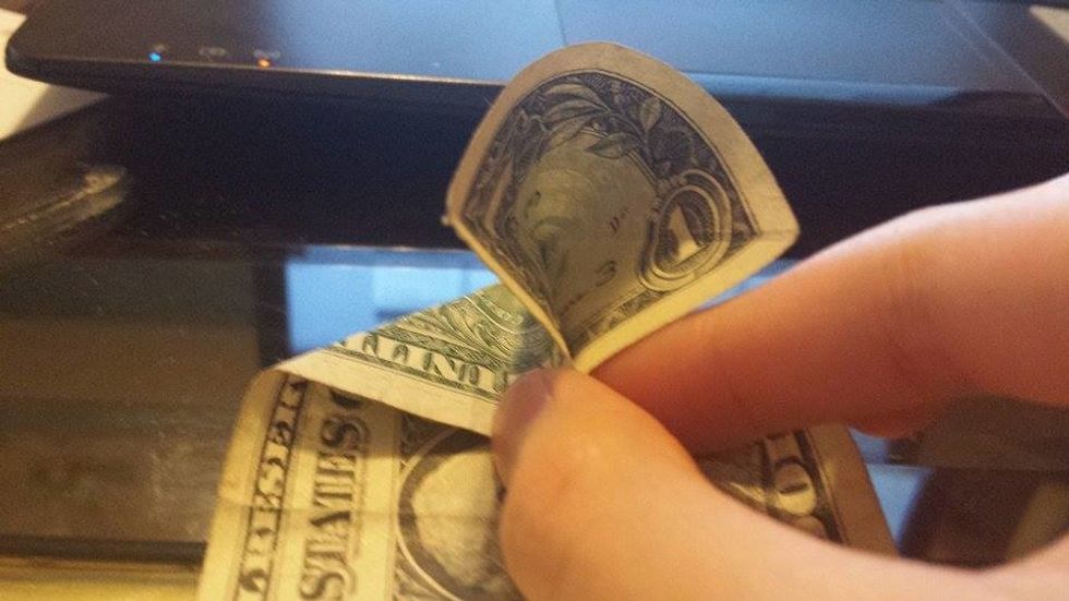 Position your dollar bill vertically. Pinch the right sides.