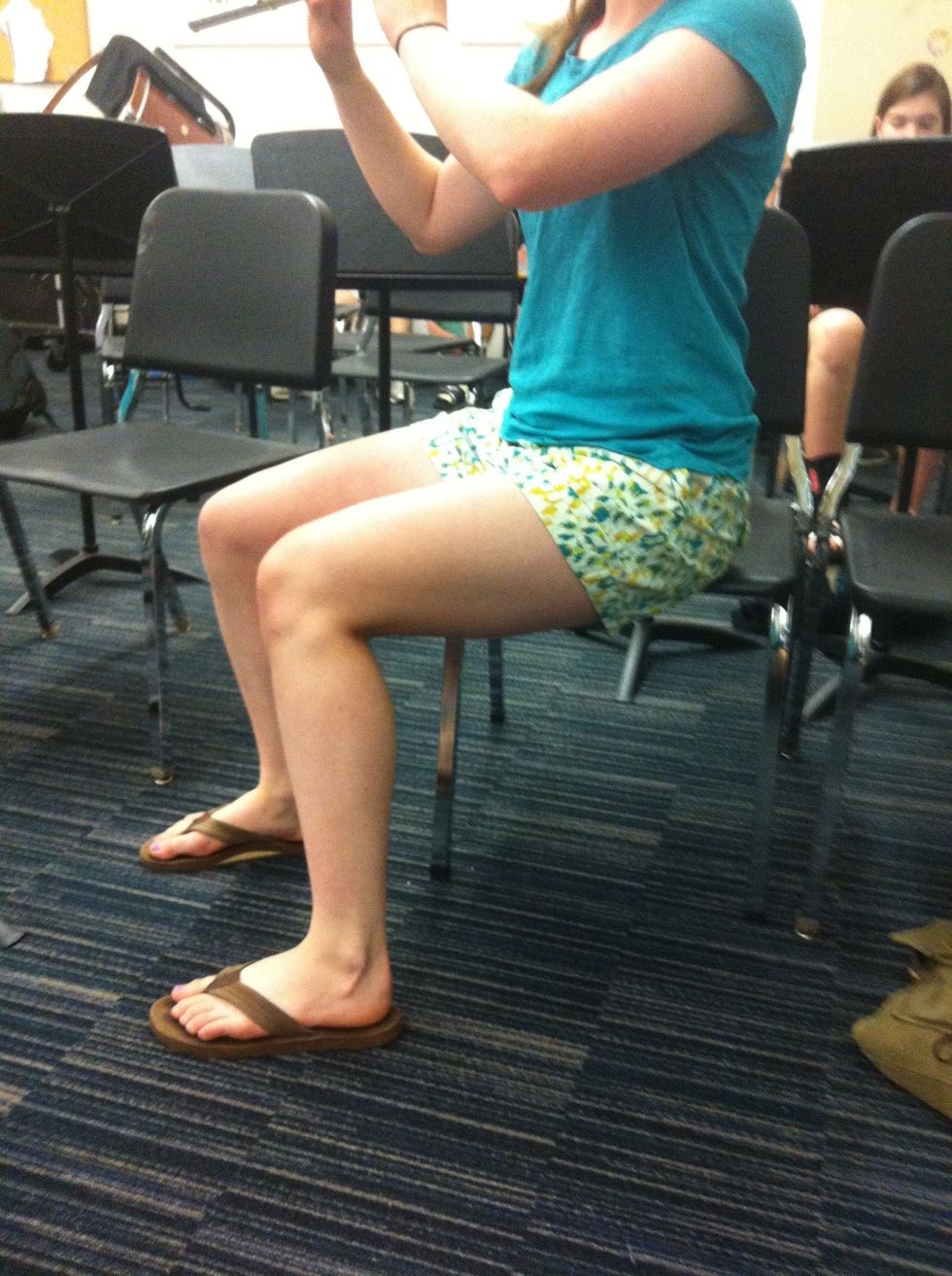Posture: sit on the edge of the chair with feet flat on the ground. Because your flute is positioned to the right, people often sit slanted to the right so the can see the music as shown above.